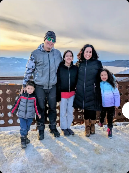 Jessica and her family in winter gear on snow at Mount Washington, New Hampshire