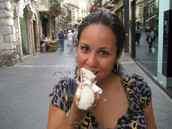 Jessica with cannoli on a street in Taormina, Sicily